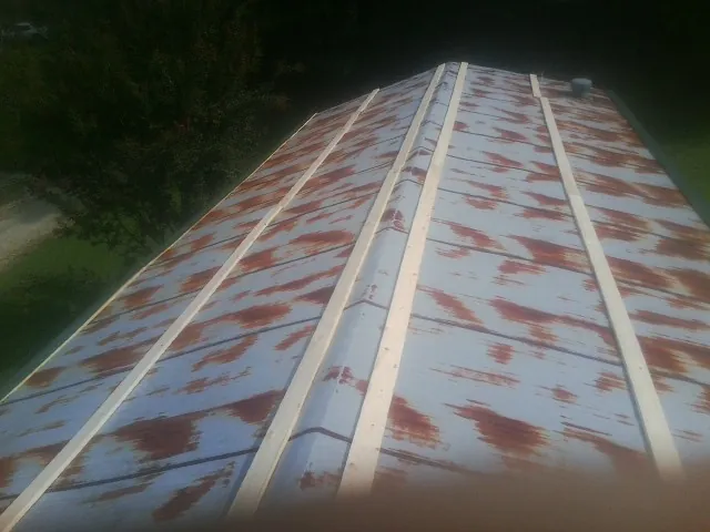 Rusted metal roof panels with new wood purlins before replacement — Storm Damage Roof Repair in Springville by Roofing Brothers