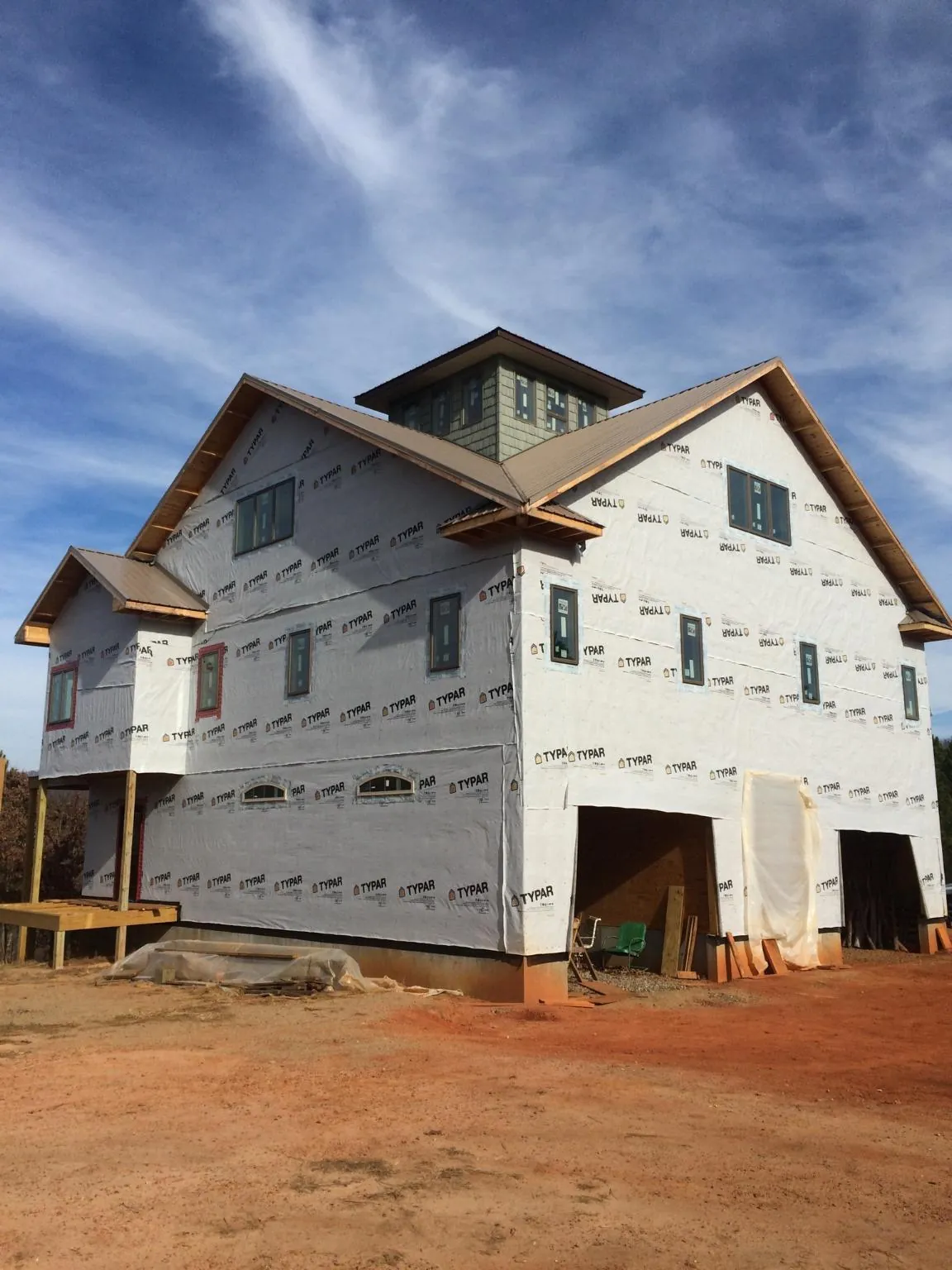 New two story house under construction with a cupola and gabled roofs in Springville